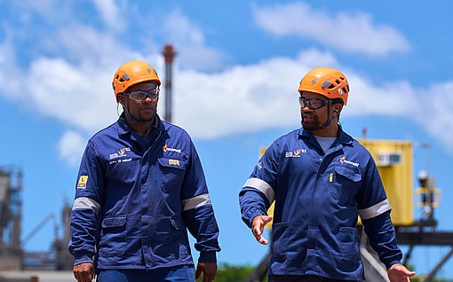 Two Mondi colleagues in hard hats walk outside of a manufacturing plant.