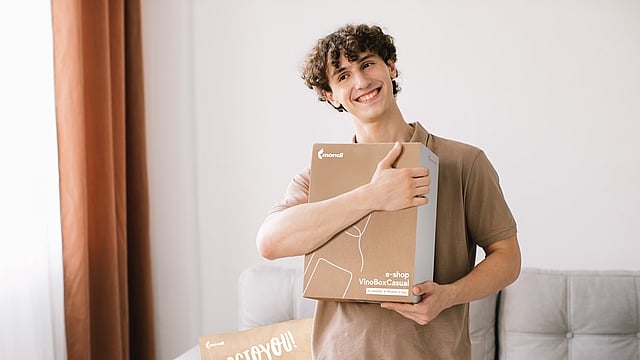 Smiling man with corrugated box in his hands