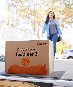 A woman walks into a house. At the doorstep lies a brown corrugated box with the writing ProVantage Testliner 3.