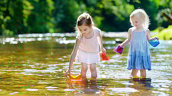 Two little girls play in the river