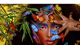 A woman surrounded by colourful butterflies and plants.