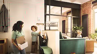 A woman and a boy in a kitchen area sorting corrugated boxes.