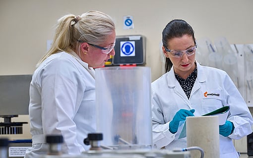 Two Mondi colleagues inspect a document.