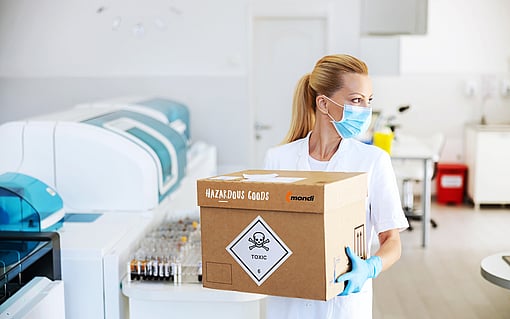 A woman carrying a corrugated box with dangerous goods.