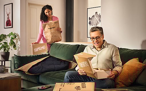 A man and woman are in their living room surrounded by Mondi eCommerce corrugated packaging solutions.