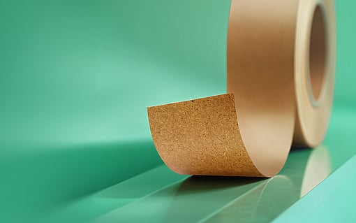 Brown release liner in a roll on a green background