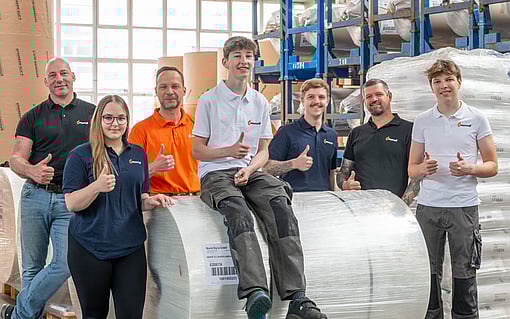 Six people in Mondi t-shirts in a factory setting giving a thumbs up