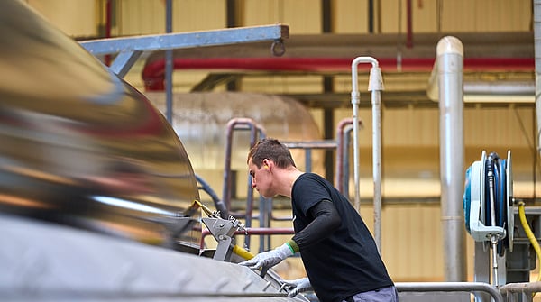 A man is operating a paper machine.