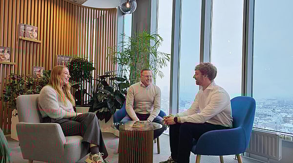 three white men in white shirts sitting in a circle having a discussion