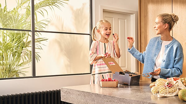 a woman and a girl in a kitchen eating food