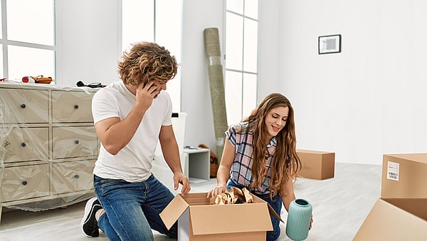 A man and a woman unpacking items from a corrugated box