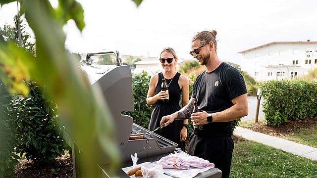 Zwei Mitarbeiter:innen beim Grillen