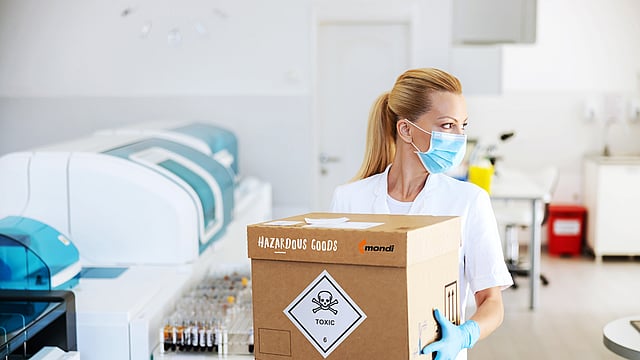 A woman carrying a corrugated box with dangerous goods.
