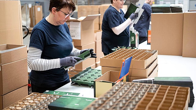 Arbeiterinnen, die Produkte einpacken.