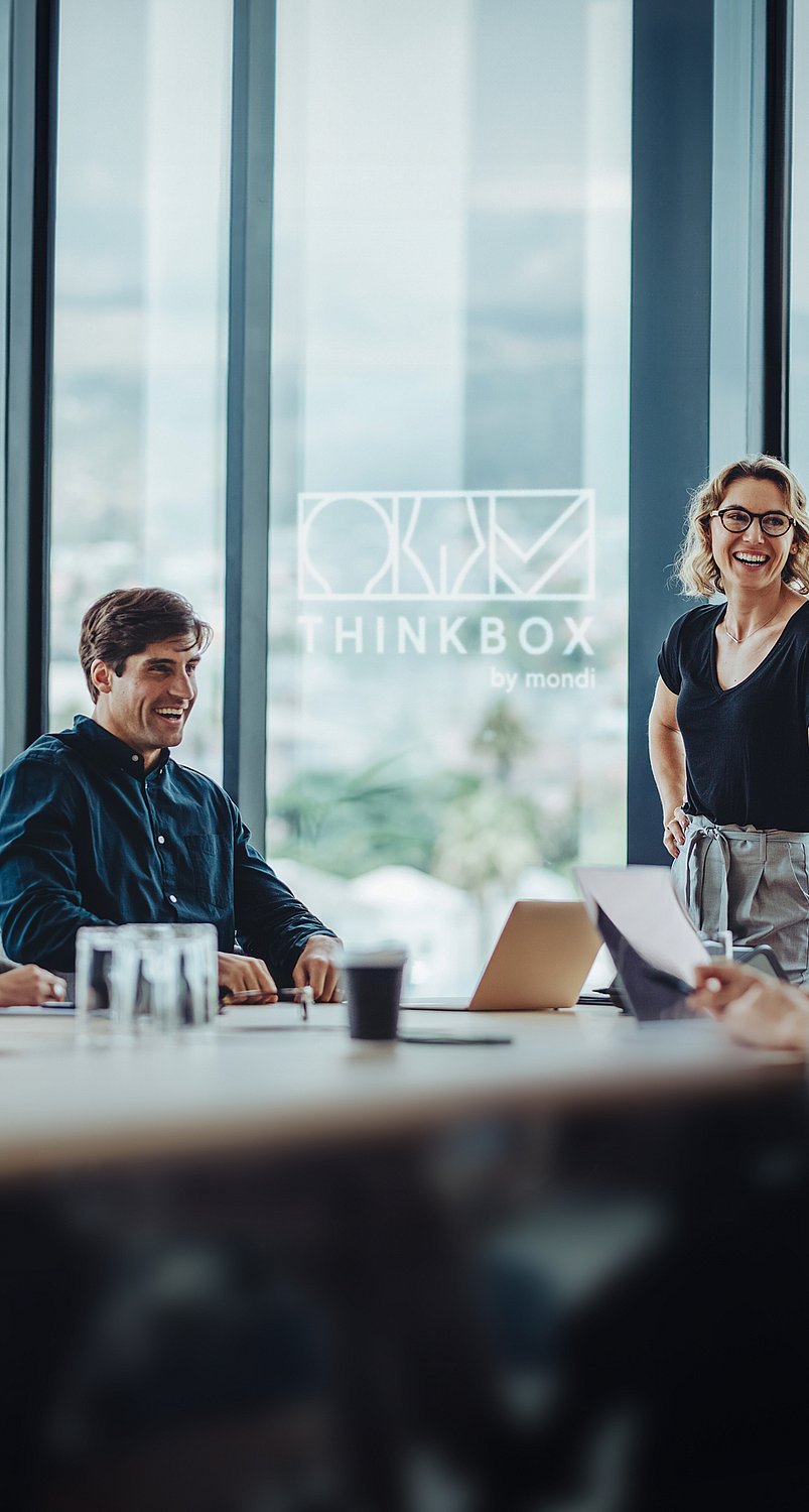 A group of people having a conversation around a table in a virtual ThinkBox space.