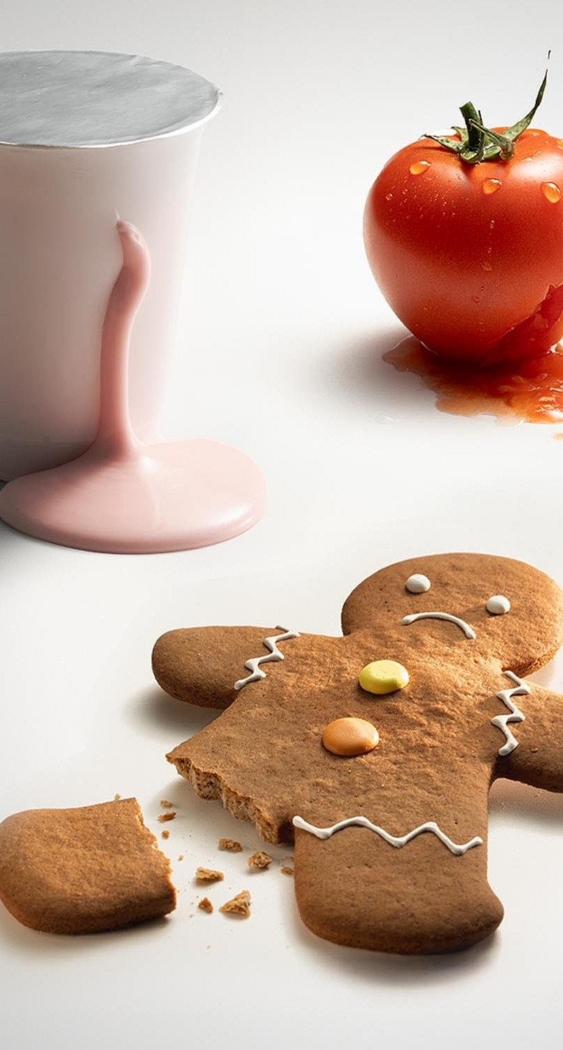 gingerbread man with broken off leg, tomato and mug on a white background