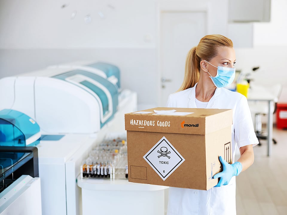 A woman carrying a corrugated box with dangerous goods.