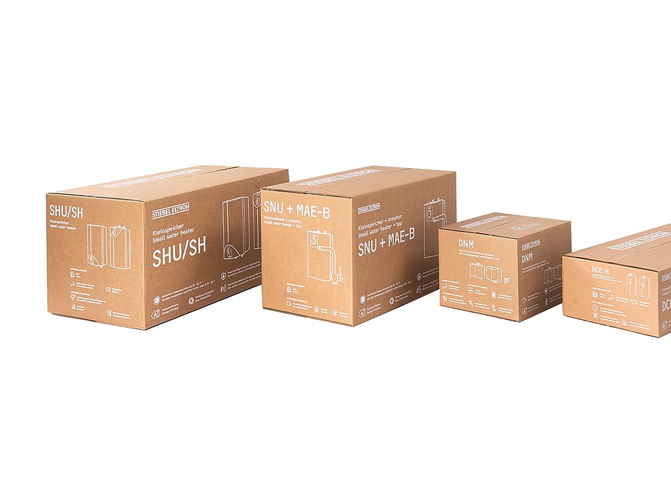 Four brown corrugated cardboard product packaging boxes of different sizes displayed in a row against a light grey background. The boxes feature white technical line drawings, product names, and specifications printed on the sides, showcasing a range of compact water heater packaging designs.