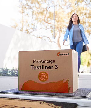 A woman walks into a house. At the doorstep lies a brown corrugated box with the writing ProVantage Testliner 3.