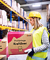 A woman in a warehouse holding a corrugated box with the words ProVantage Kraftliner written on it.c