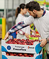 A man stacking a corrugated tray filled with apples labelled ProVantage Frescoflute.
