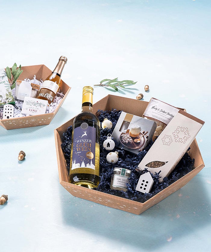 Corrugated gift baskets filled with Christmas presents such as chocolate, alcohol, and jam.