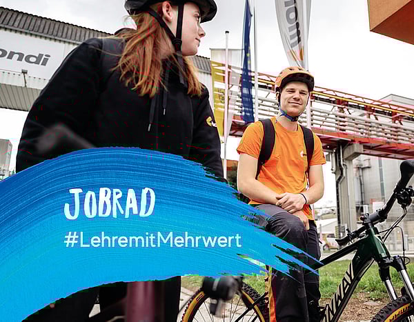 Zwei Mitarbeitende mit einem Jobrad