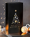A black corrugated gift box decorated with Christmas ornaments in a festive setting.