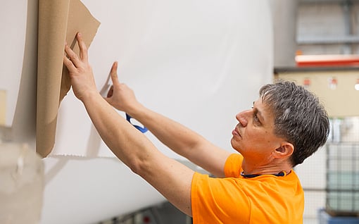 A Mondi colleague inspecting a sheet of containerboard.