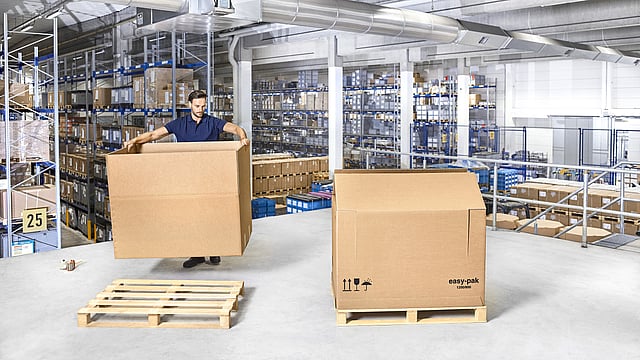 Ein Arbeiter beim Arbeiten mit Wellpappkartons.