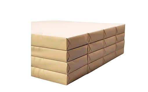 Stack of beige paper sheets or reams bundled together with straps against a neutral background.