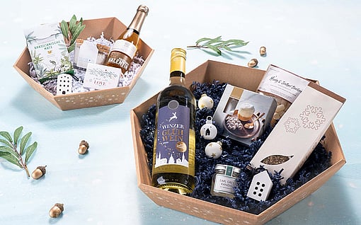 Corrugated gift baskets filled with Christmas presents such as chocolate, alcohol, and jam.