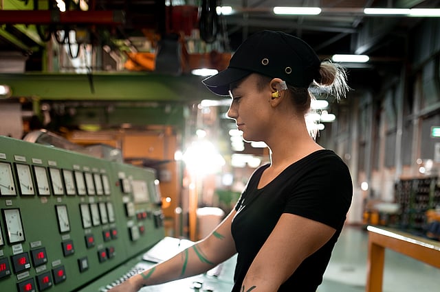 Mitarbeiterin an der Maschine in der Produktion