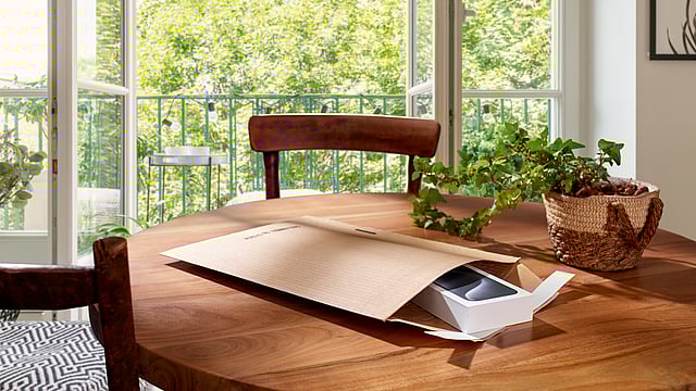 A protective mailer with a phone inside which is on a table.