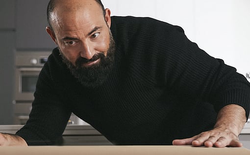 A smile of satisfaction spreads across a man's face as he gazes at the cardboard container, admiring its sturdy and versatile design.