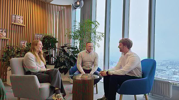 three white men in white shirts sitting in a circle having a discussion